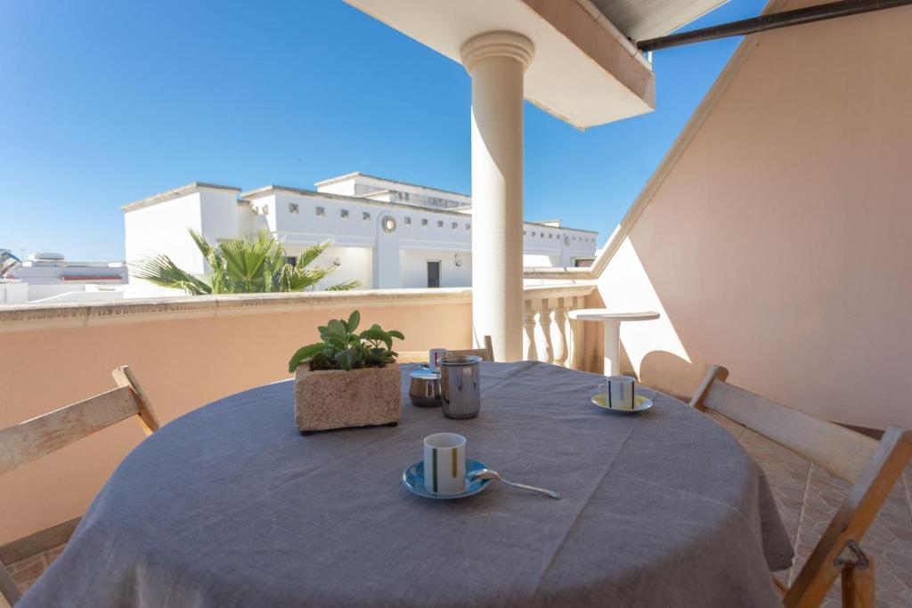 une table avec un chiffon bleu sur un balcon dans l'établissement Appartamento Torre San Giovanni, à Torre San Giovanni