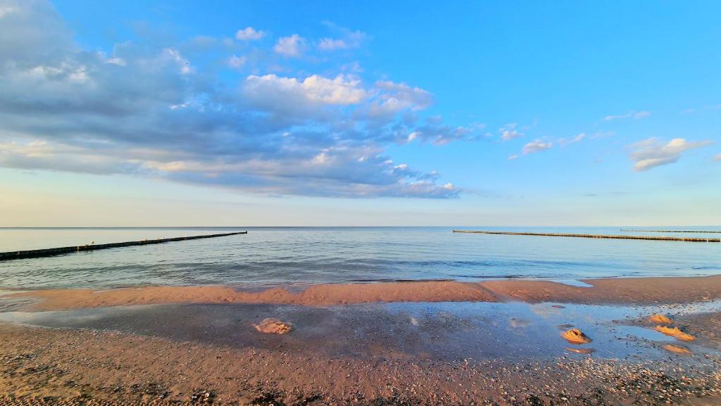 una vista del océano con un muelle en el agua en Kos - Bungalow "Kapitänskajüte ", en Ostseebad Koserow