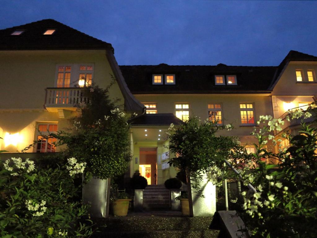 ein großes Haus in der Nacht mit eingeschaltetem Licht in der Unterkunft Relaxa at a luxurious villa in Bad Pyrmont in Bad Pyrmont