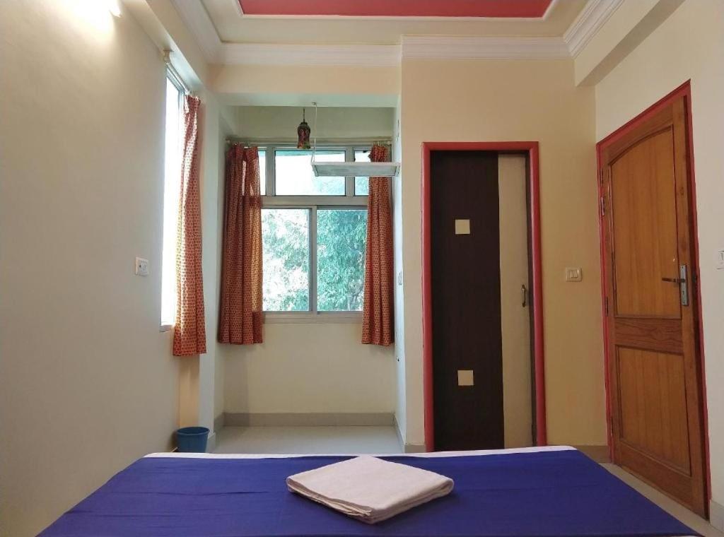 a bedroom with a blue bed and a window at Panna Palace Guest House in Udaipur