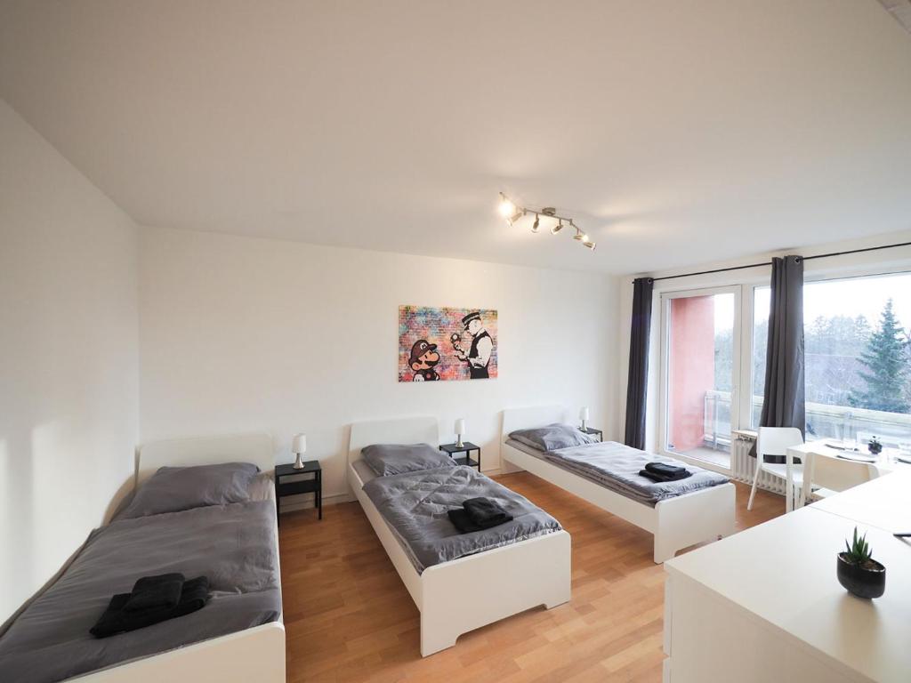 ein weißes Zimmer mit 2 Betten und einem Tisch in der Unterkunft Nice Apartment in Bargteheide (Hamburg) in Bargteheide