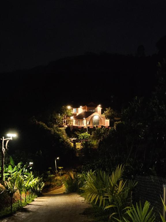 une maison sur une colline la nuit dans l'établissement Nhà Gạch cổ - Antique Brick House, à Bảo Lâm