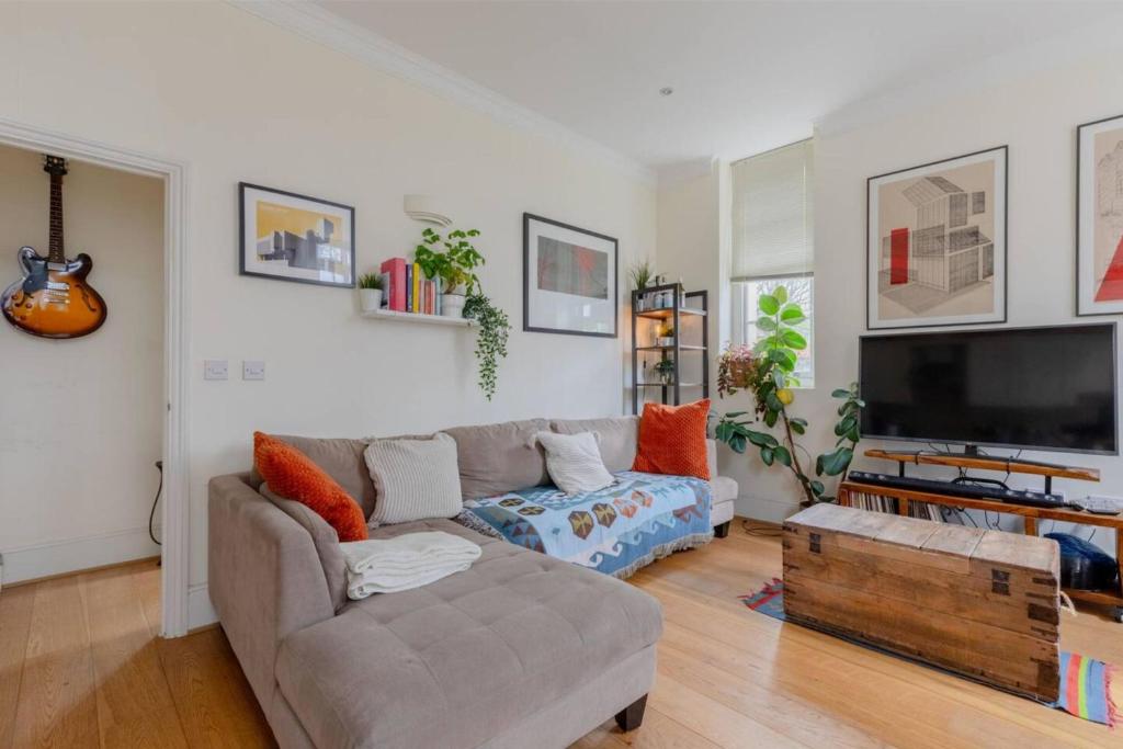 a living room with a couch and a flat screen tv at Stylish Bohemian 2BD Flat Mile End Park! in London