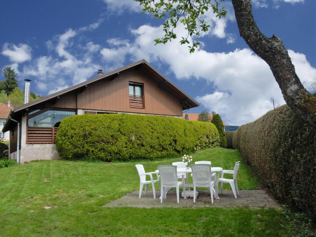 uma mesa e cadeiras em frente a uma casa em Elegant Chalet in Gerb pal in cosy environment em Gerbépal