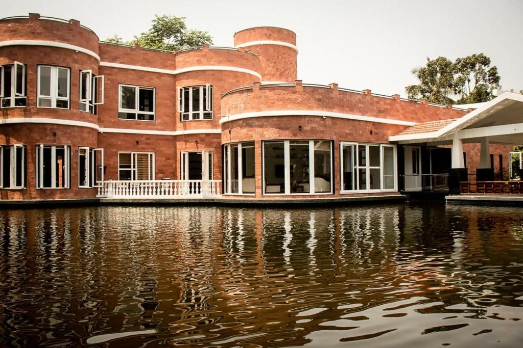 un grand bâtiment en briques sur une étendue d'eau dans l'établissement Torch Ginger Homestay, à Sultan Bathery