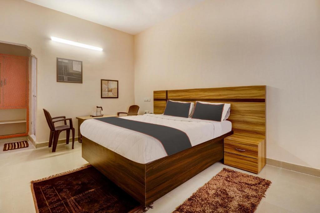 una camera con letto, scrivania e sedia di Super OYO V M Inn a Tirupati
