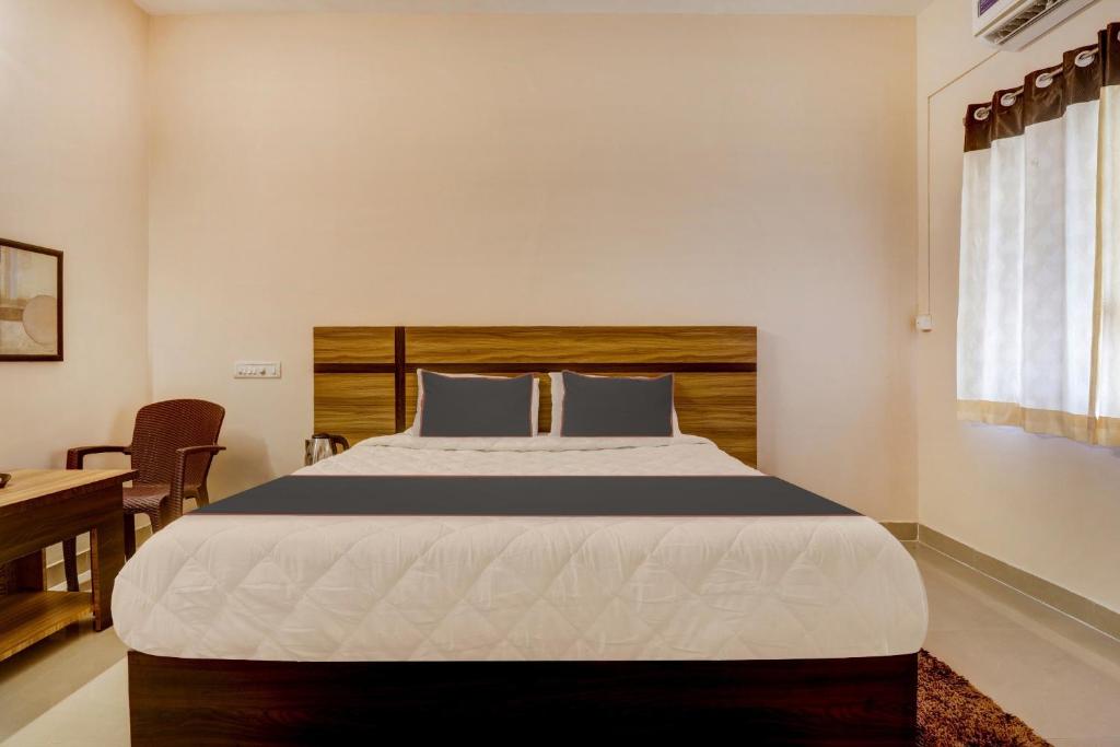 een slaapkamer met een groot bed met een houten hoofdeinde bij Super OYO V M Inn in Tirupati