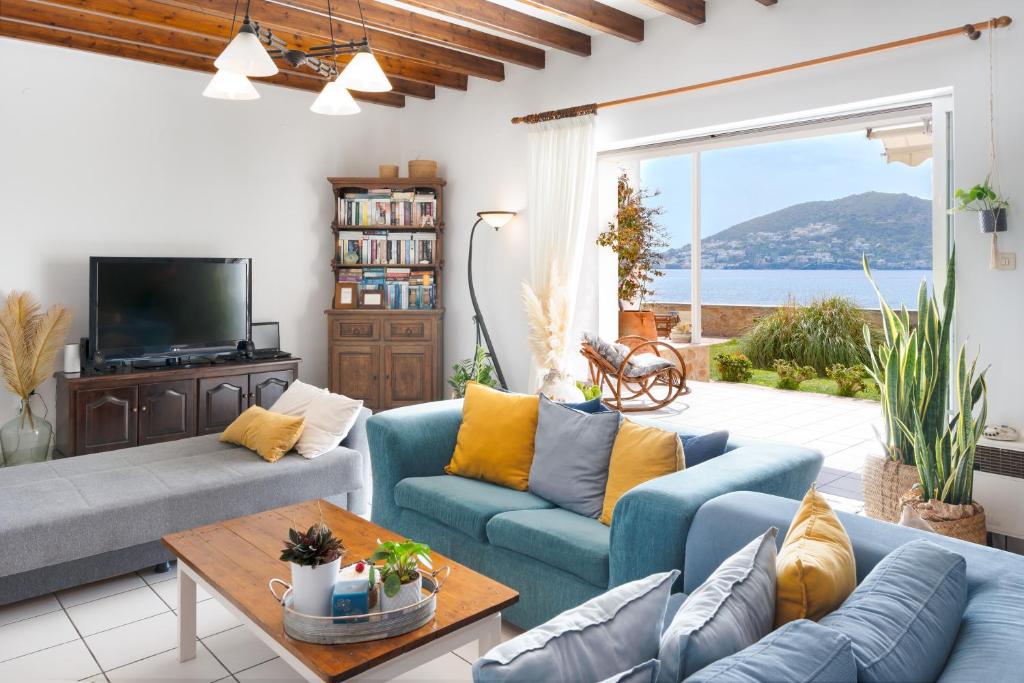 a living room with blue couches and a view of the ocean at Villa peristeri in Alinda
