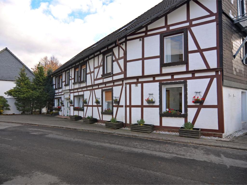a white and brown building with potted plants on it at Modern group of homes close to Willingen and Winterberg with large garden in Medebach