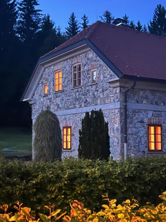 une maison en pierre dotée de lumières orange. dans l'établissement Vila Bajer, à Stari Trg pri Ložu