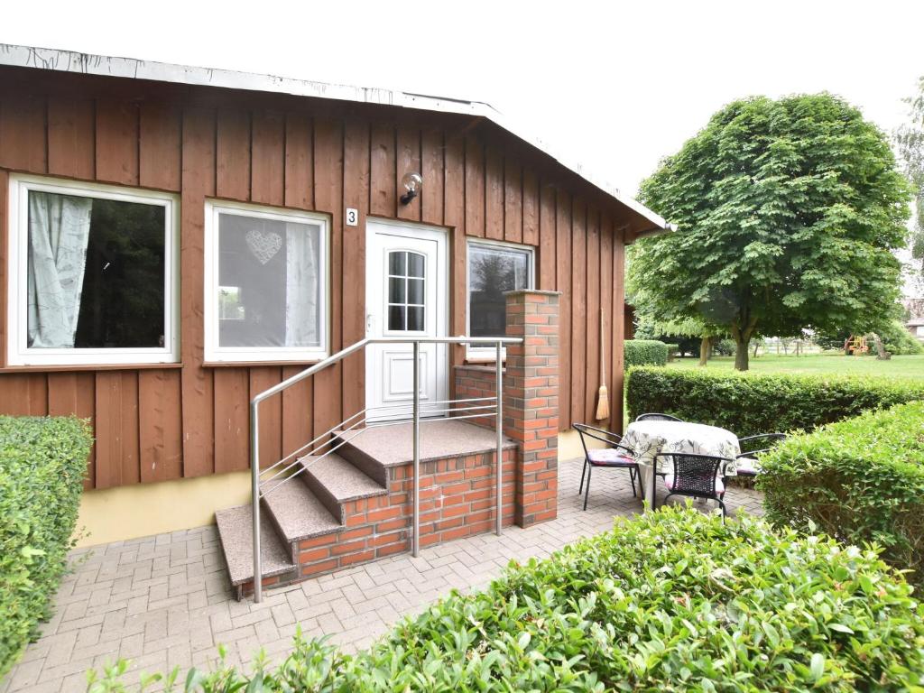 a small house with a staircase and a patio at Quaint Bungalow near Insel Poel with Garden in Insel Poel
