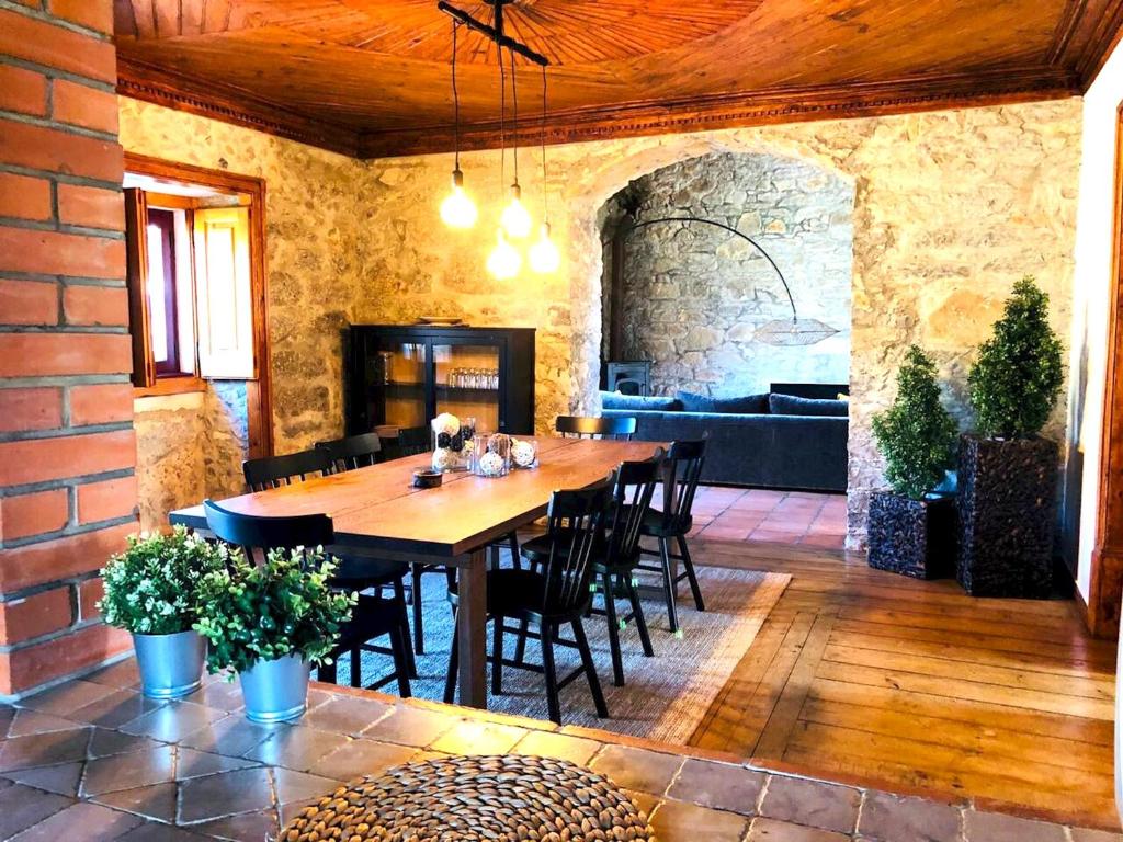 uma sala de jantar com uma mesa de madeira e cadeiras em 3 bedrooms house with private pool terrace and wifi at Porto de Mos em Porto de Mós