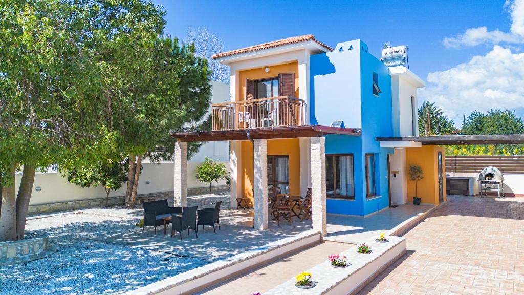 Casa azul y amarilla con patio en Villa Joan, en Ayios Theodhoros