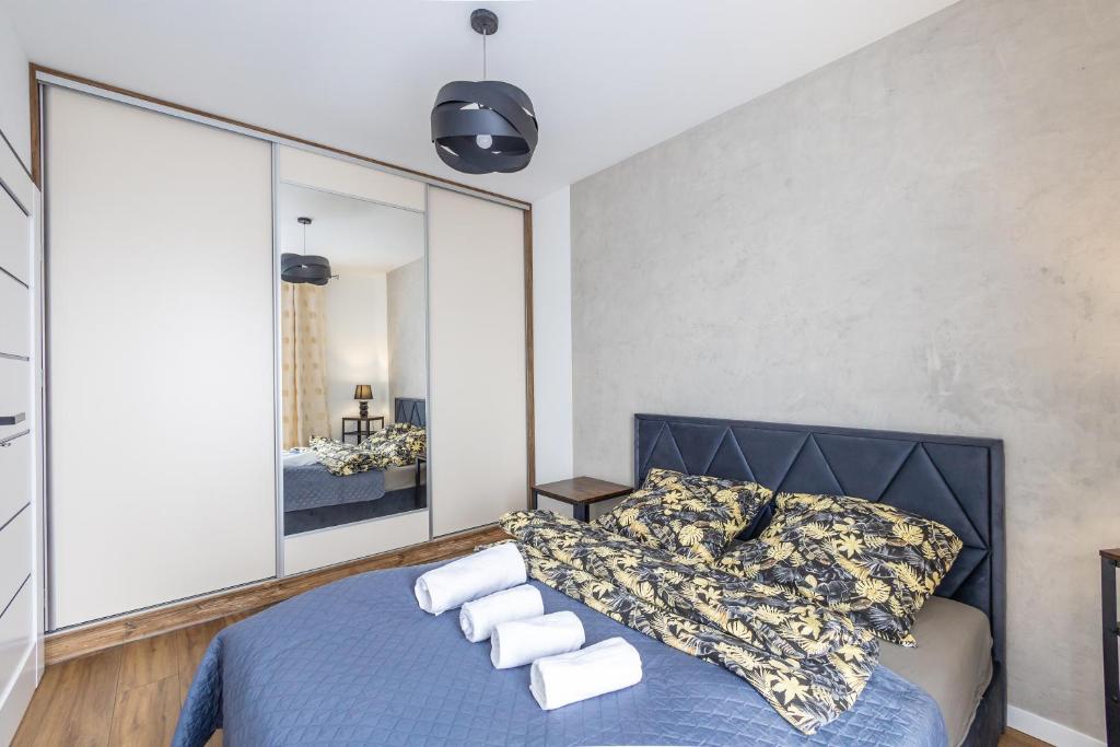 a bedroom with a blue bed and a large mirror at Apartament 33 in Gąski