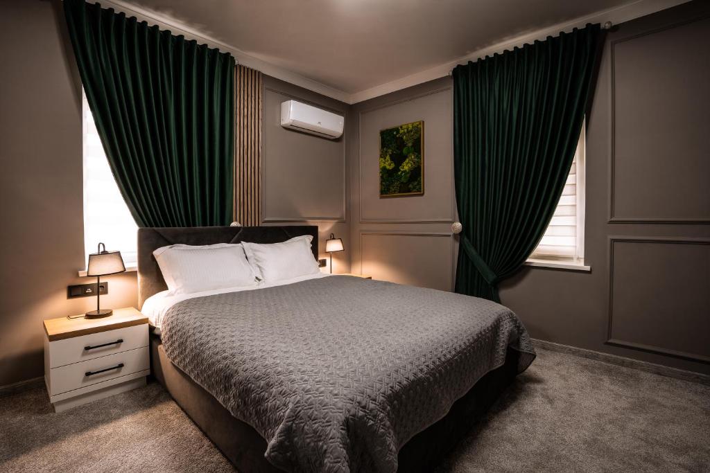 a bedroom with a bed with green drapes at Sobor Family Resort in Stavcheny