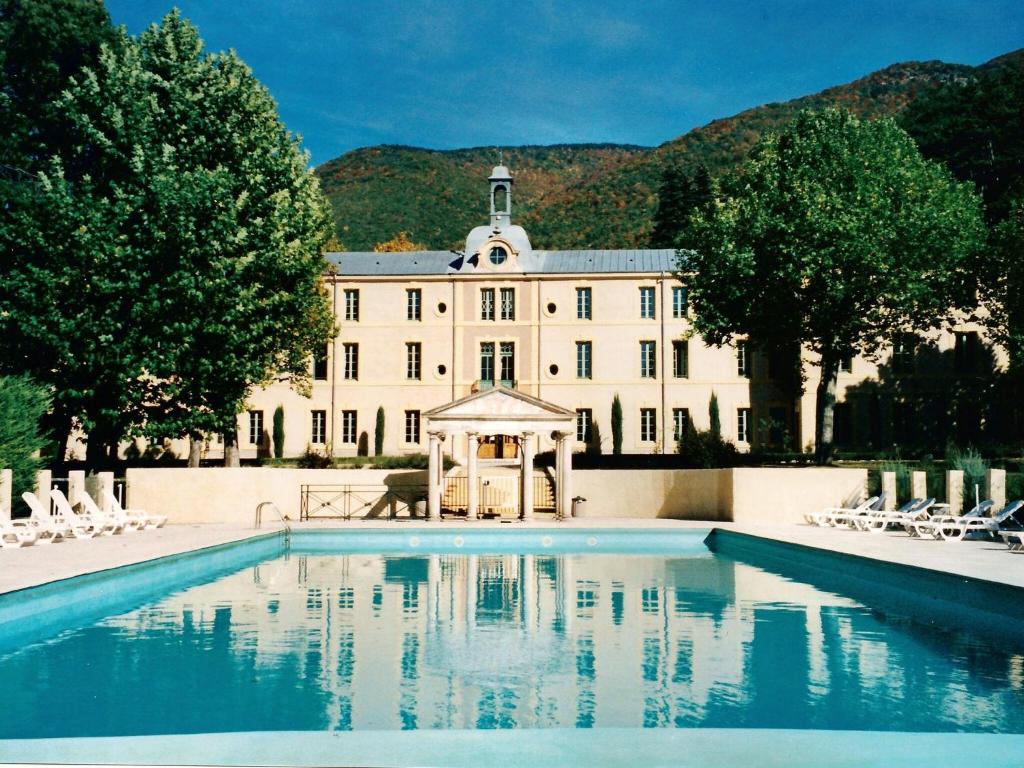 una casa grande con piscina frente a ella en A beautiful 2 persons studio in a chateau with swimming pool, en Montbrun-les-Bains