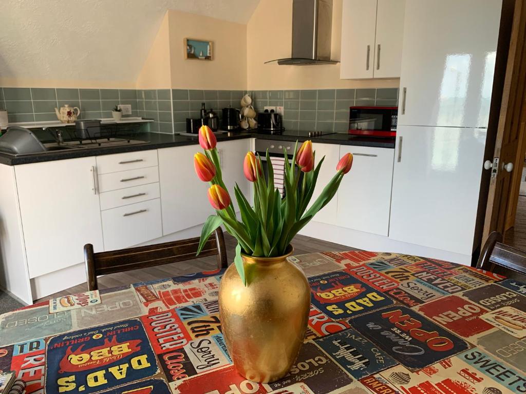 a vase with tulips in it sitting on a table at Flat, amazing balcony sea view, bike store, with sun deck in Margate