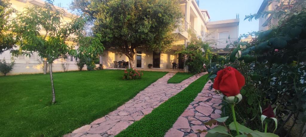 a garden with a red flower in a yard at “Villa Chrysa” luxury house in Flámbouras