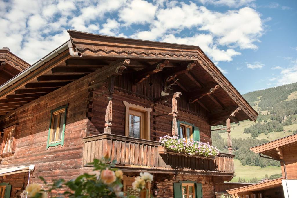 a log cabin with a balcony and flowers on it at Jagahäusel Appartement Gitti in Jochberg