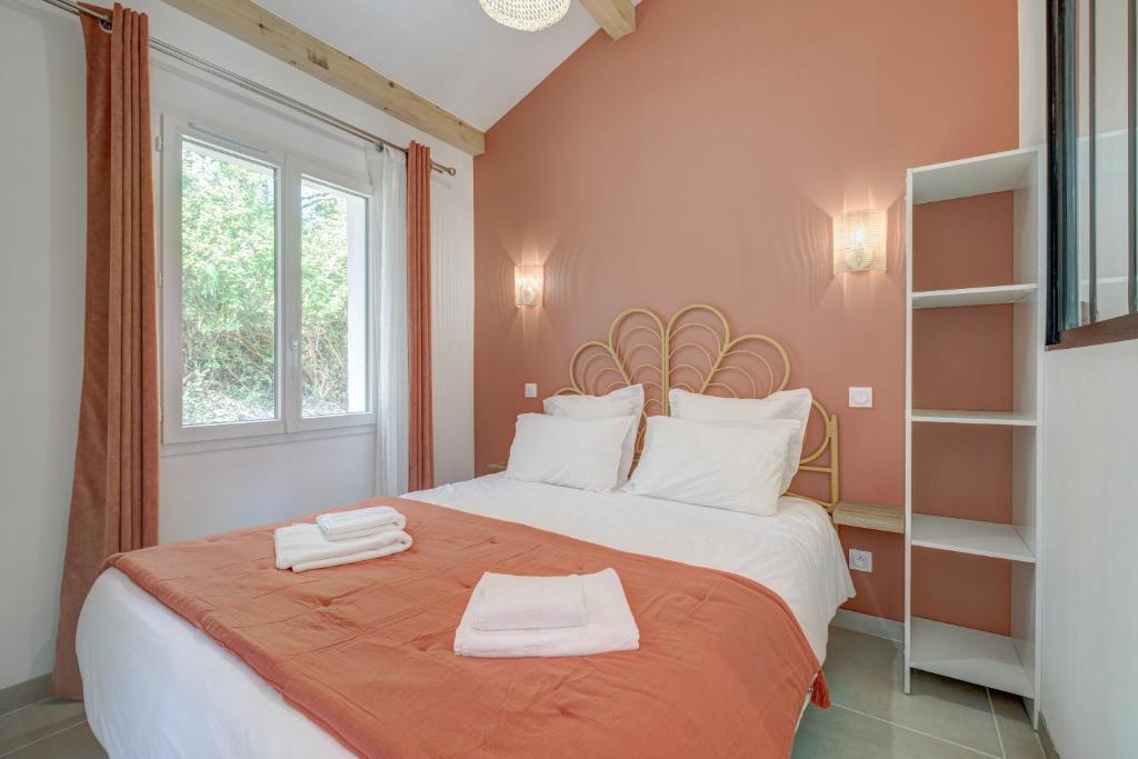 una camera da letto con un letto con due asciugamani sopra di Rêves de pampa Casa Bohème a Lorgues