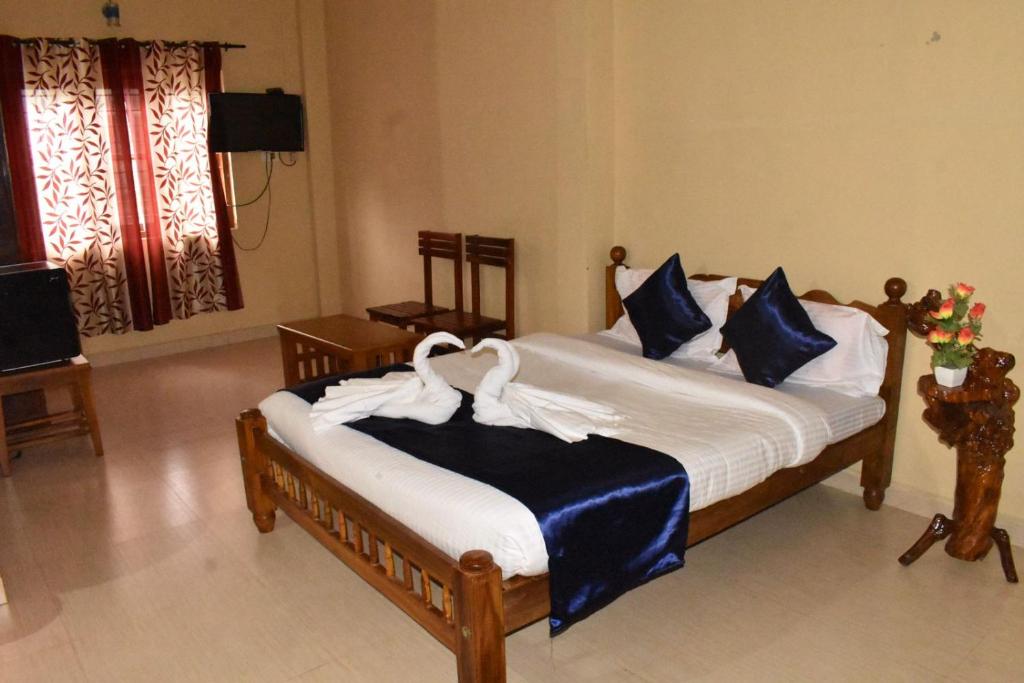 1 dormitorio con 1 cama con sábanas azules y blancas en OYO Home Inn Of Dreams Homestay, en Wayanad