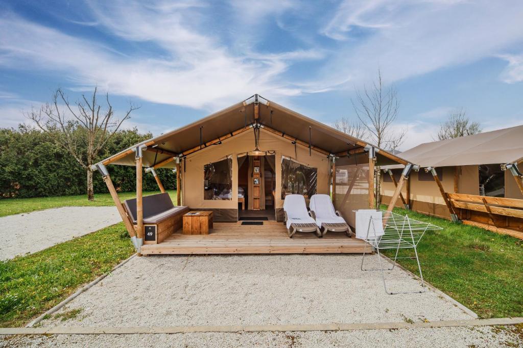 a large tent with two chairs and a porch at Glamping Tents in Tuhelj with thermal riviera tickets in Tuheljske Toplice