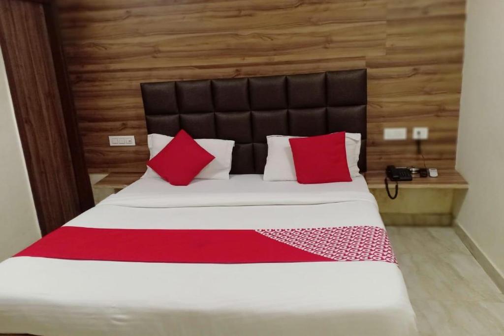 a bedroom with a large bed with red pillows at OYO Hotel Cloud 9 in Zirakpur