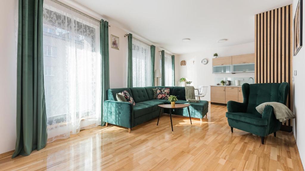 un soggiorno con un divano verde e 2 sedie di Apartamenty Sun & Snow Angel City a Cracovia