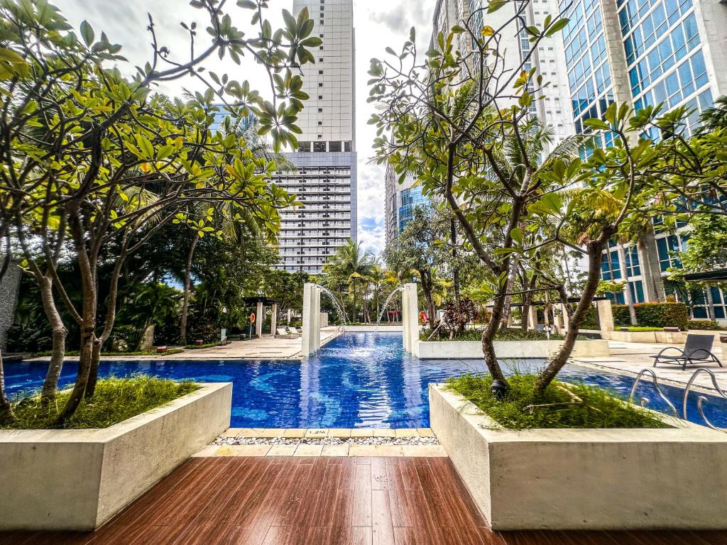 a pool in the middle of a city with tall buildings at Exquisite 3BR Surabaya Apartment at Via Tower Ciputra World by Le Ciel Hospitality in Surabaya