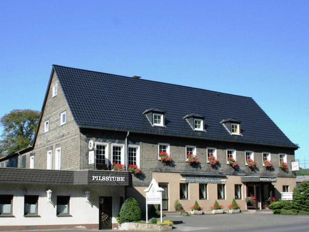 duży budynek z czarnym dachem w obiekcie Apartment near ski area in Wehrstapel in Sauerland w mieście Meschede