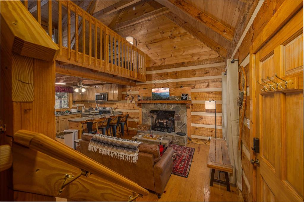 a living room with a fireplace in a log cabin at Hidden Hideaway cabin in Cosby
