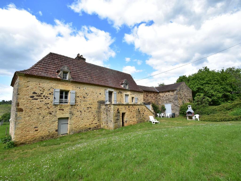an old brick house on a hill with two chairs at Beautiful holiday home in wooded grounds near Villefranche du P rigord 7 km in Villefranche-du-Périgord