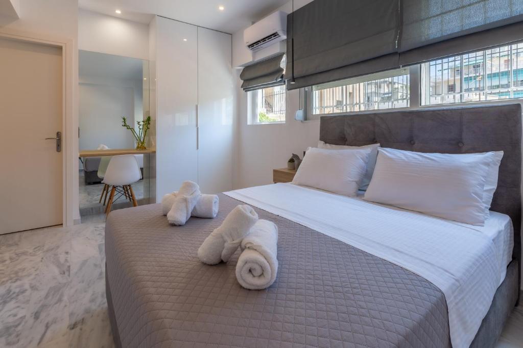 Mandevilia Suites في أثينا: غرفة نوم بسرير كبير عليها مناشف