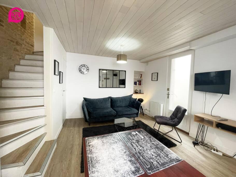ein Wohnzimmer mit einem blauen Sofa und einer Treppe in der Unterkunft Le Paul by iZiLi - Centre Ville - Gare in Niort