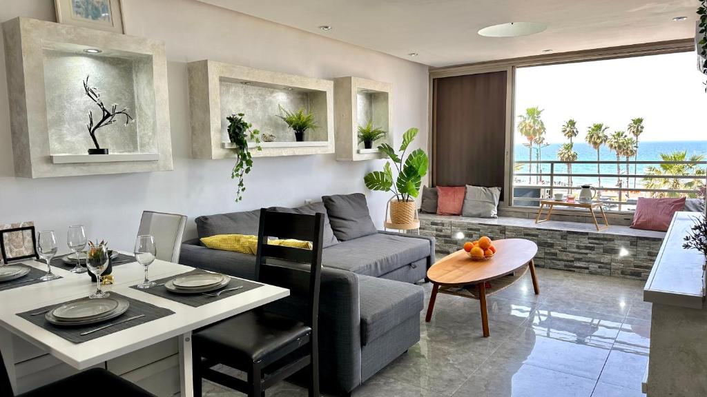 uma sala de estar com um sofá e uma mesa em Diamond 2bed apartment with jacuzzi by the sea em Haifa