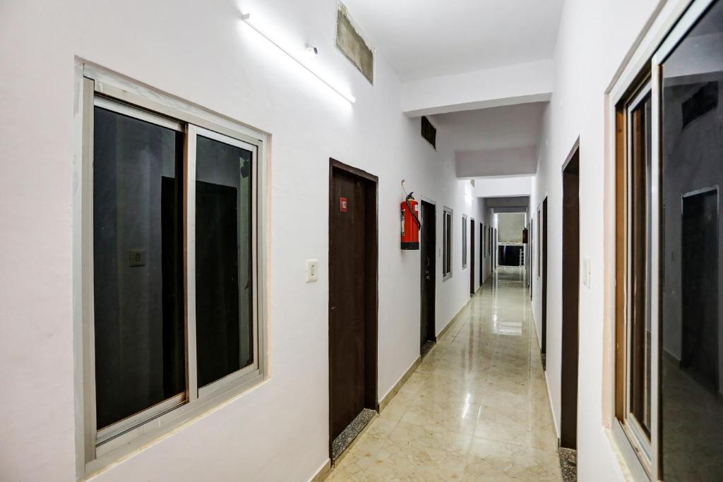 um corredor com paredes e janelas brancas em OYO Hotel 99 em Rewāri