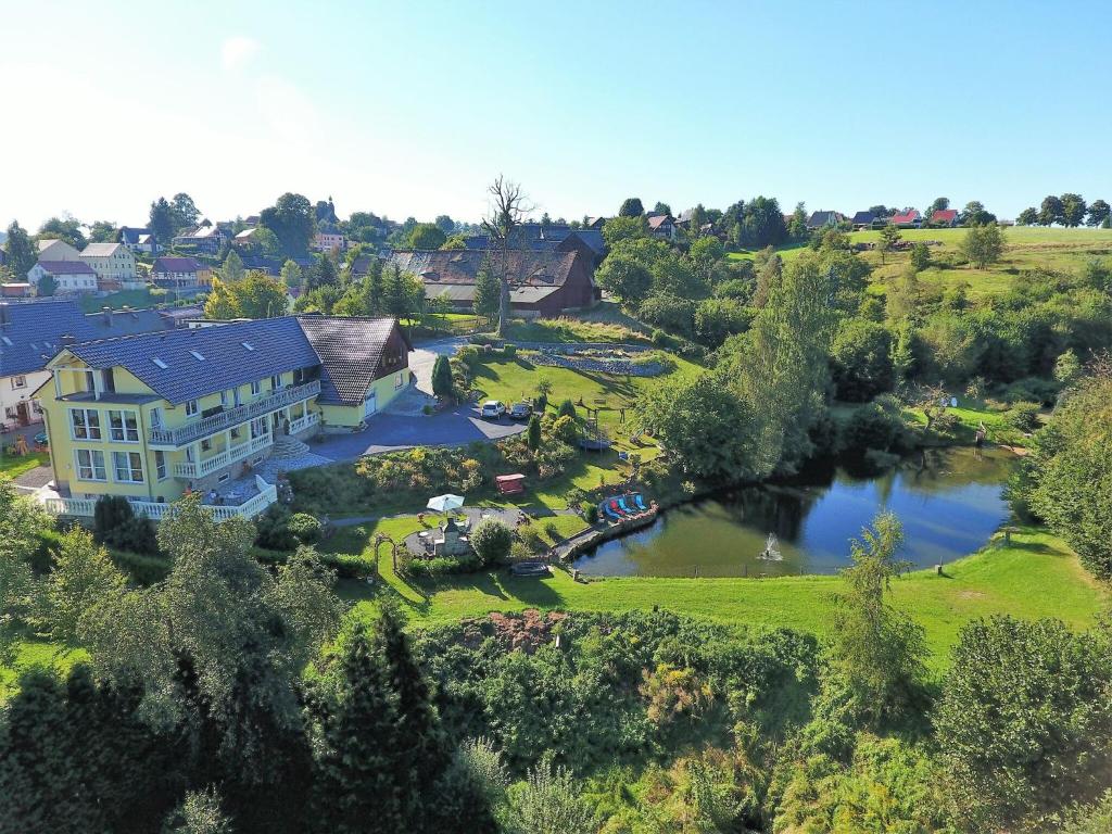 una vista aérea de una casa y un lago en Roomy Apartment in Lichtenhain with Pond, en Lichtenhain