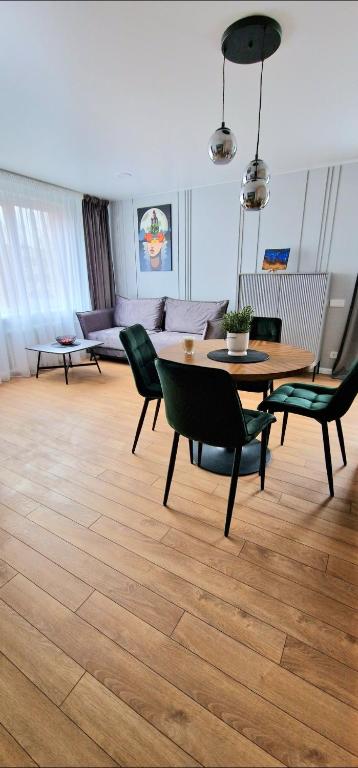 uma sala de estar com uma mesa e cadeiras e um sofá em Studijos tipo būstas em Kretinga