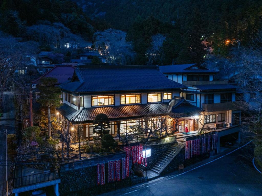 a house with lights on at night at Temple Hotel 岸之坊 in Minobu