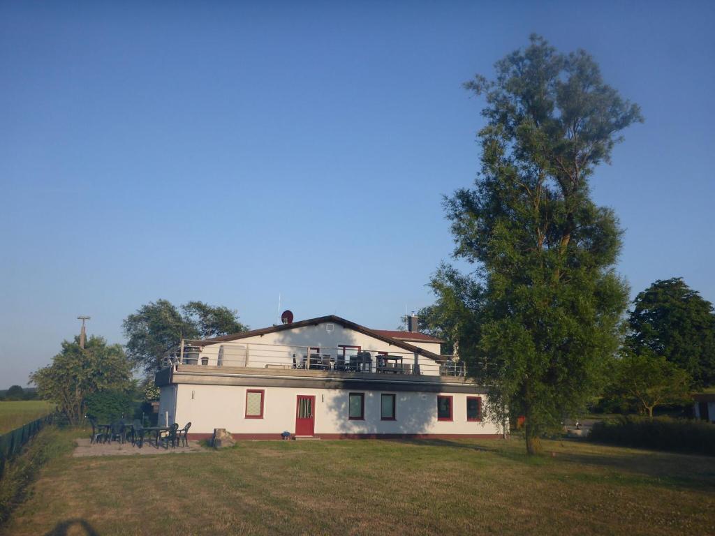 a large white house on a field with a tree at Modern Apartment in Bastorf near Sea in Bastorf