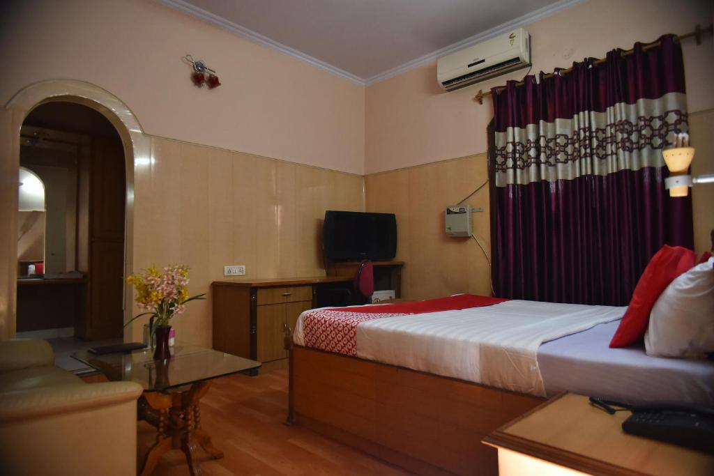 a bedroom with a bed and a couch and a television at Collection O City Heart in Hisār