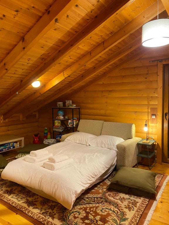 uma cama grande num quarto com tecto em madeira em ktima Tzouros - Κτήμα Τζούρος em Thermo