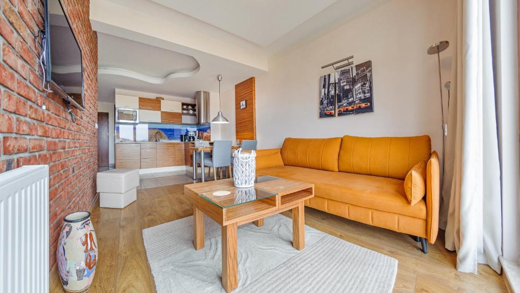 a living room with a couch and a table at Apartamenty Sun & Snow Melioracyjna in Karwia