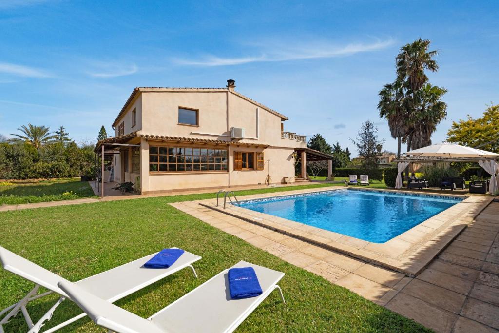 a house with a swimming pool and two lounge chairs at Villa Can Font in Palma de Mallorca