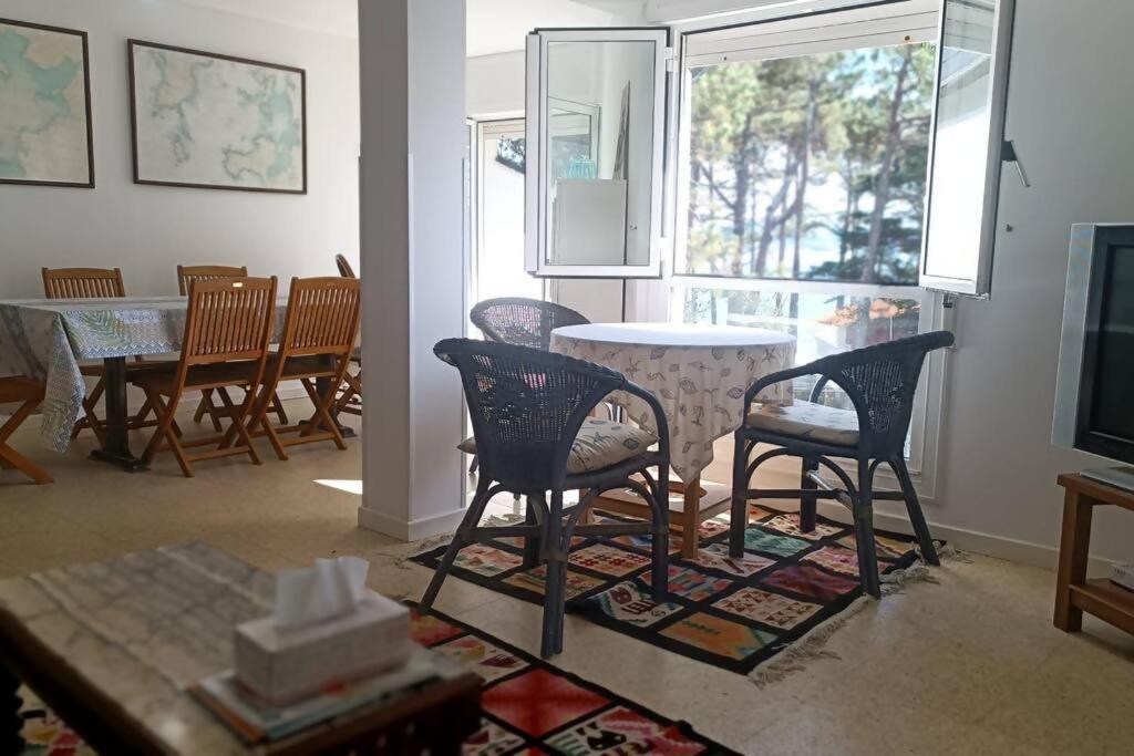 sala de estar con mesa, sillas y TV en Casa pepiño sv, en San Vicente do Mar
