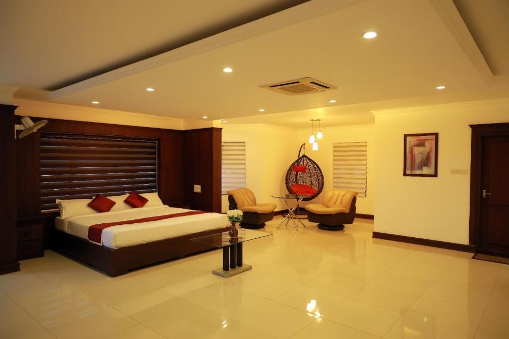 a bedroom with a bed and a desk and chair at GRANDE IVORY INN in Kalpetta