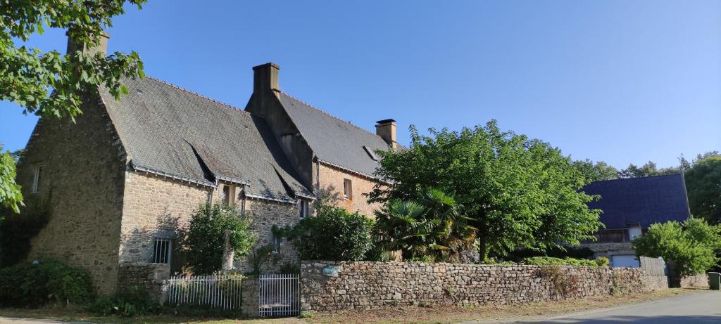 een oud bakstenen gebouw met een stenen muur bij Talvern, Les Mouettes à Landévant in Landévant