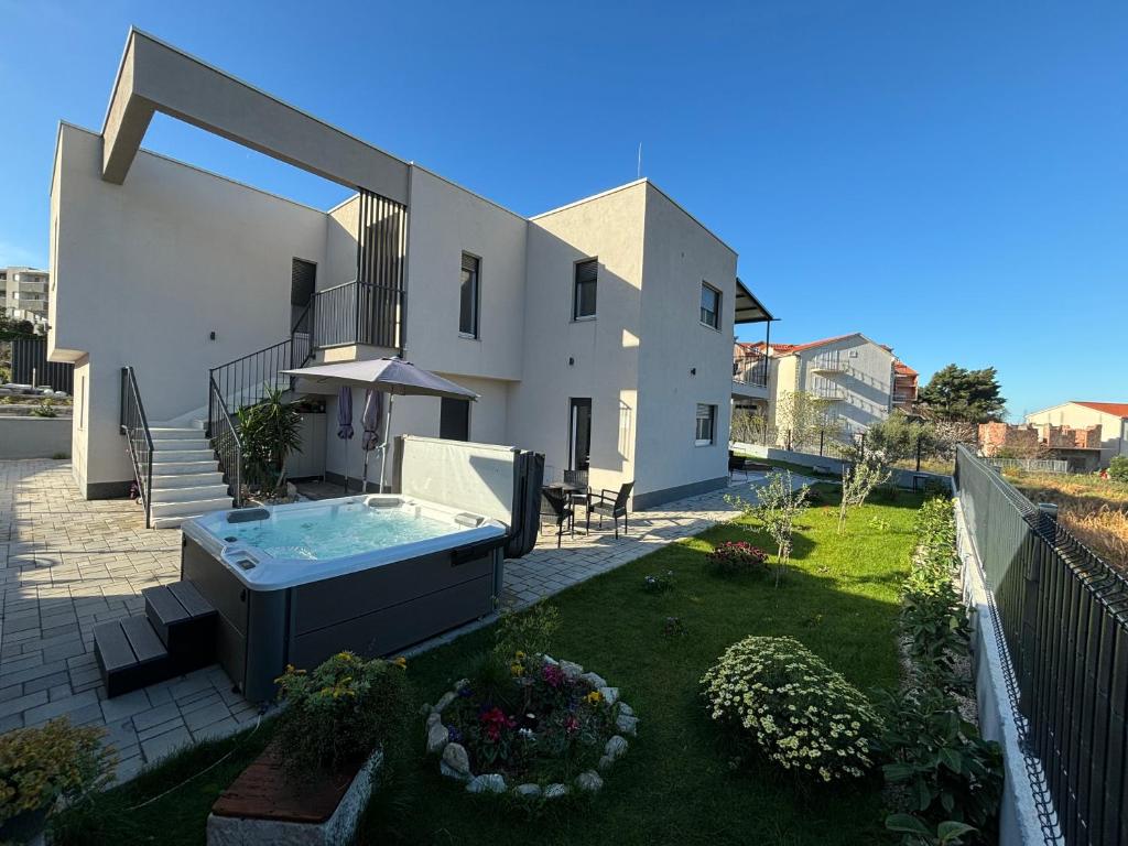 a house with a hot tub in a yard at Villa Balić - Podstrana in Podstrana