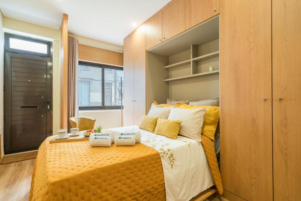 um quarto com uma cama grande e almofadas amarelas em Host Wise - Porto Urban Escape no Porto