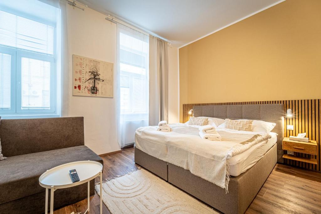 sypialnia z dużym łóżkiem i kanapą w obiekcie Design Apartments Lužánky w mieście Brno